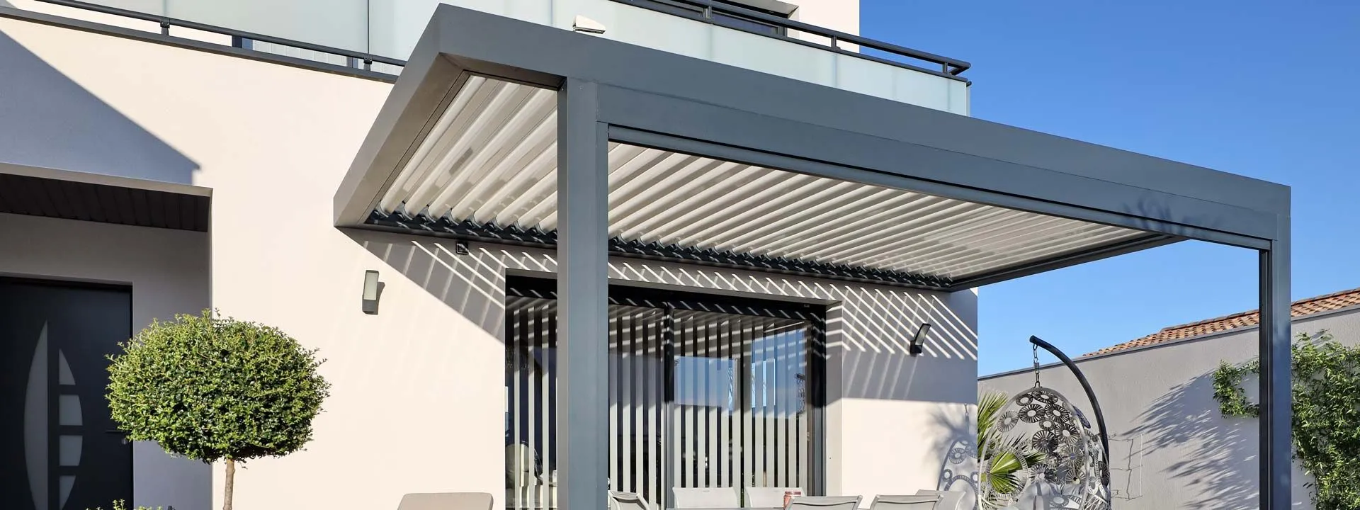 Pergola bioclimatique Solare déployée sur une terrasse en fin d'après-midi